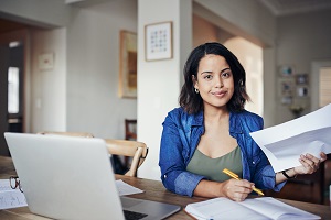 Young Woman Doing Paperwork at Kitchen Table